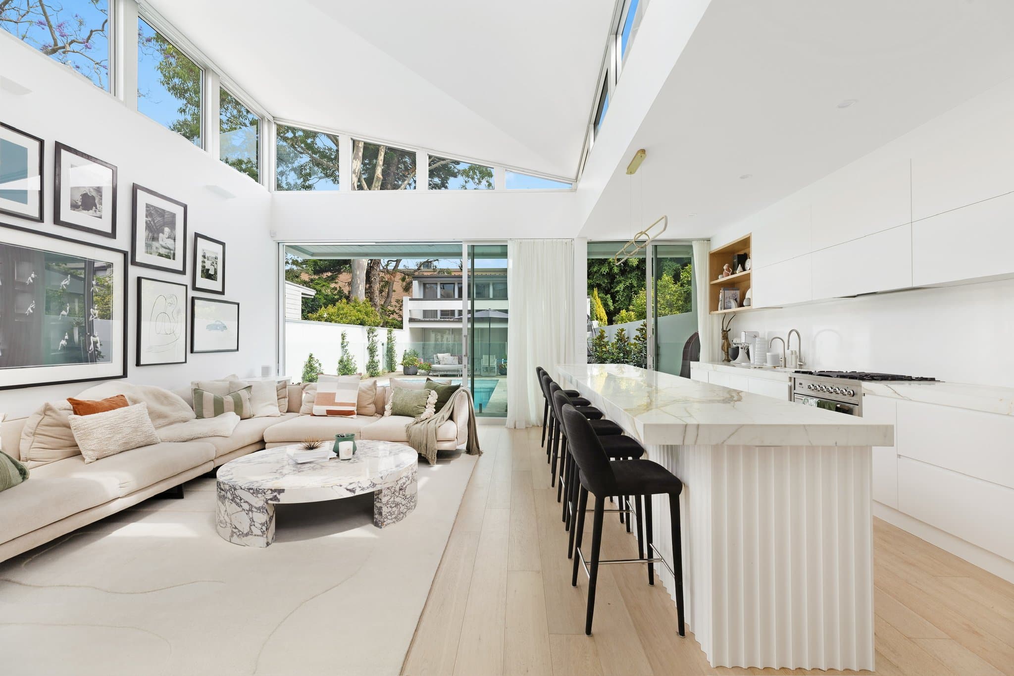 KBLCO kitchen renovation, Sydney. Bright white kitchen with a stone island and bar stools.