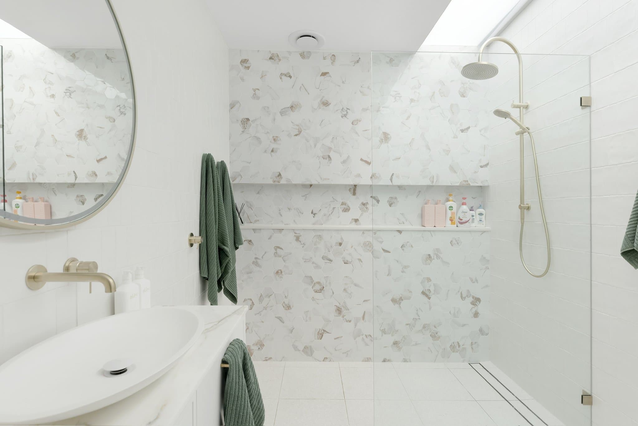 KBLCO bathroom renovation, Sydney. Marble-lined shower with brass tapware.