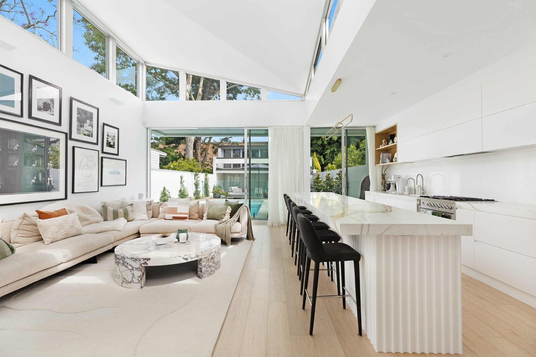 Kitchen with a stone island and bar stools.