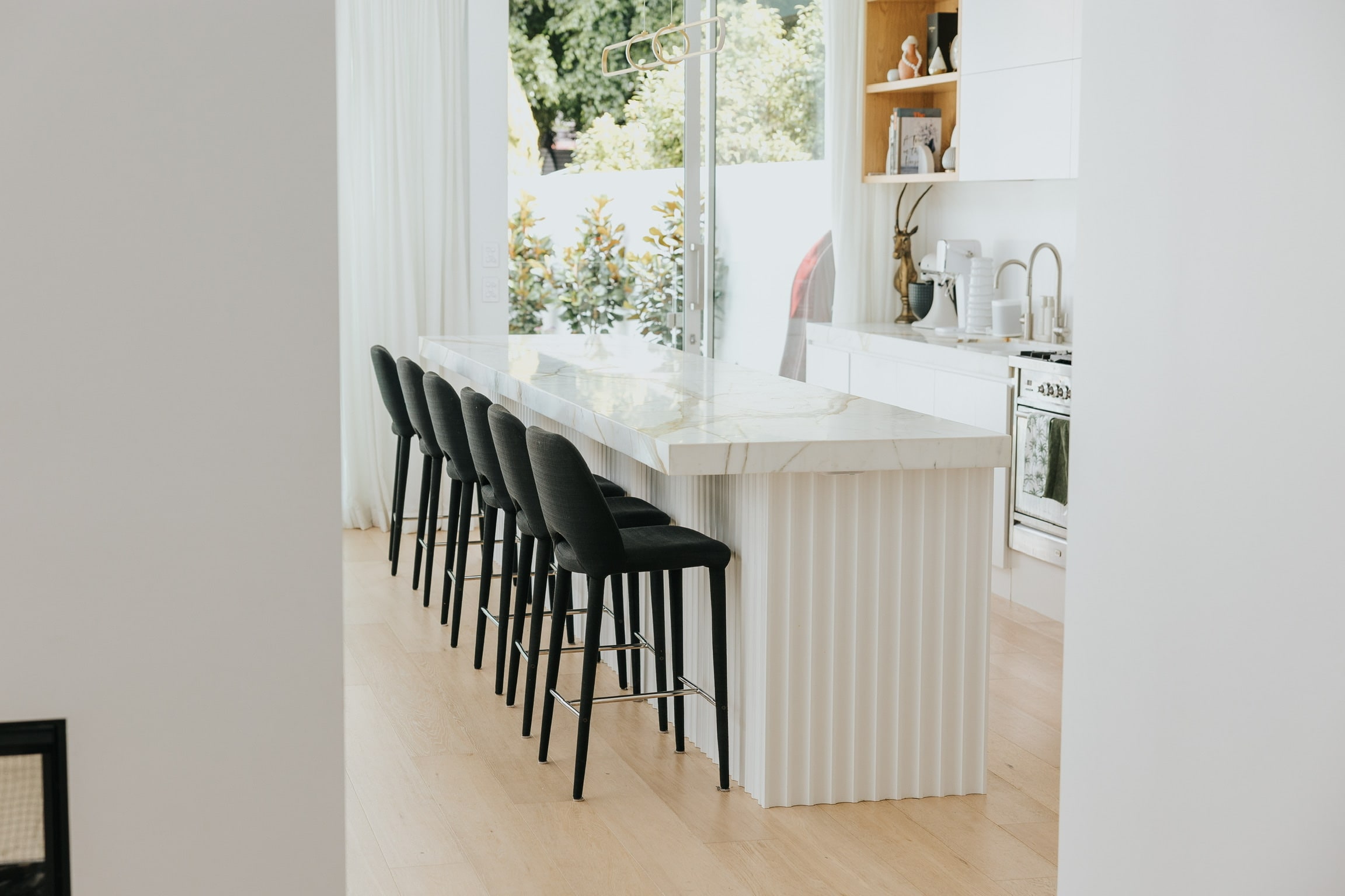 Vaulted kitchen with a fluted calacatta island and brass pendant at the Albion residence by KBL Collective Co.