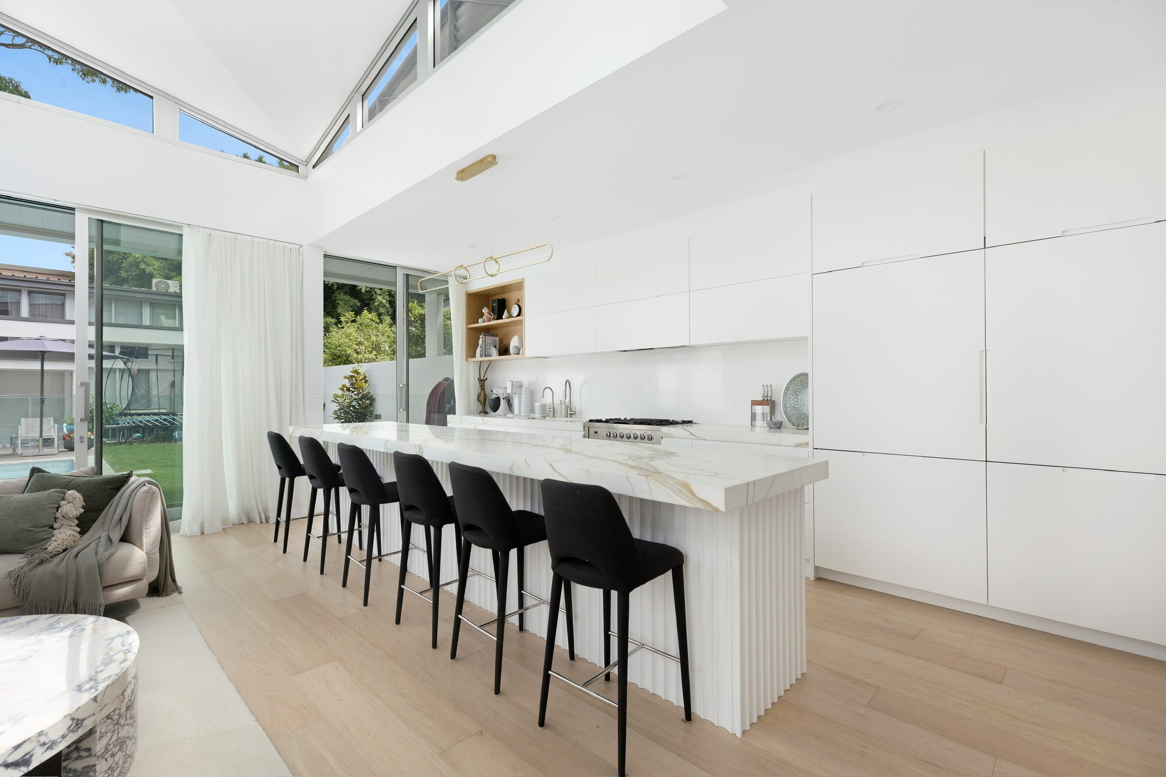 A kitchen the studio has designed, with a marble island beneath a vaulted skylight.