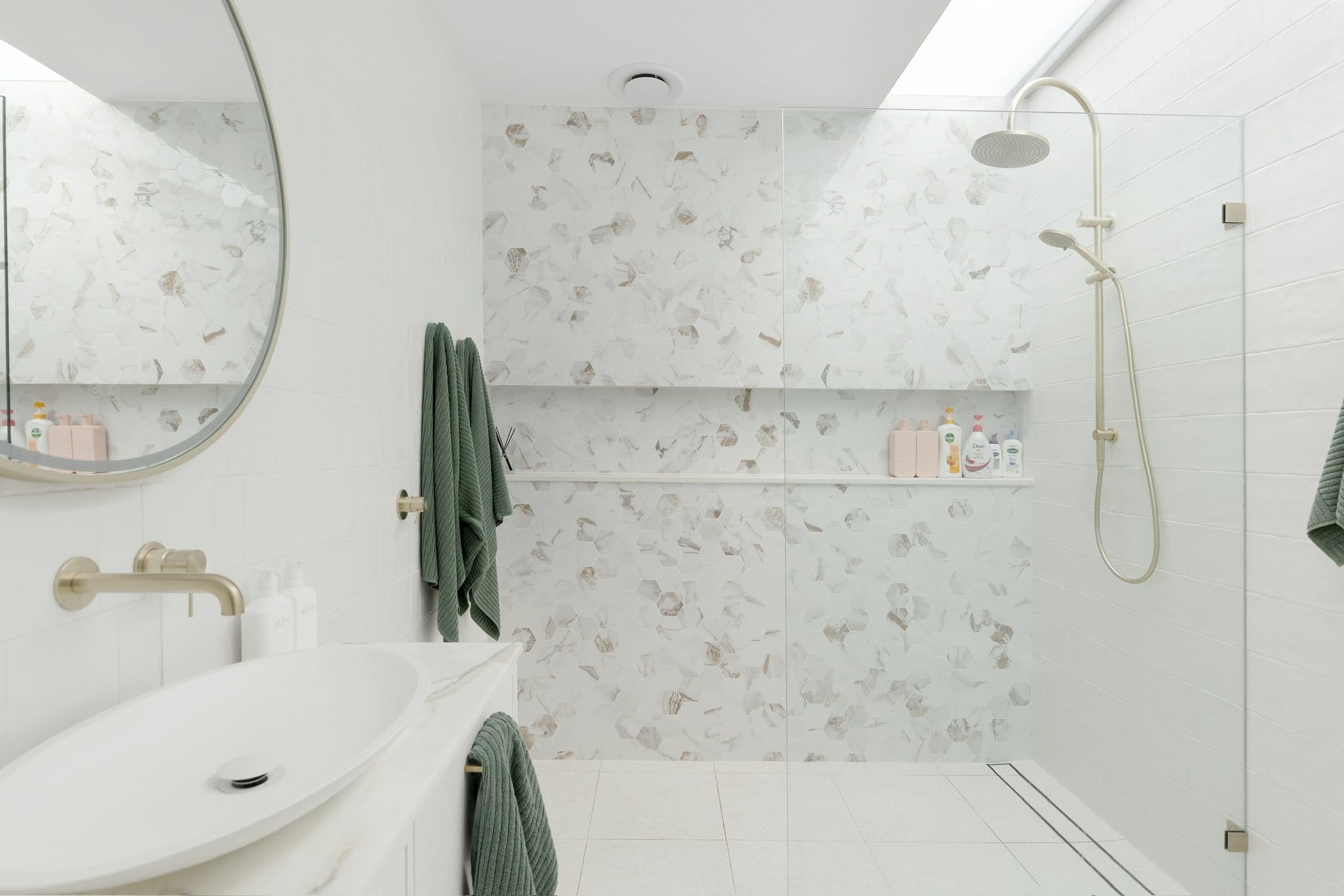 Albion bathroom with a marble-lined shower and brass tapware.
