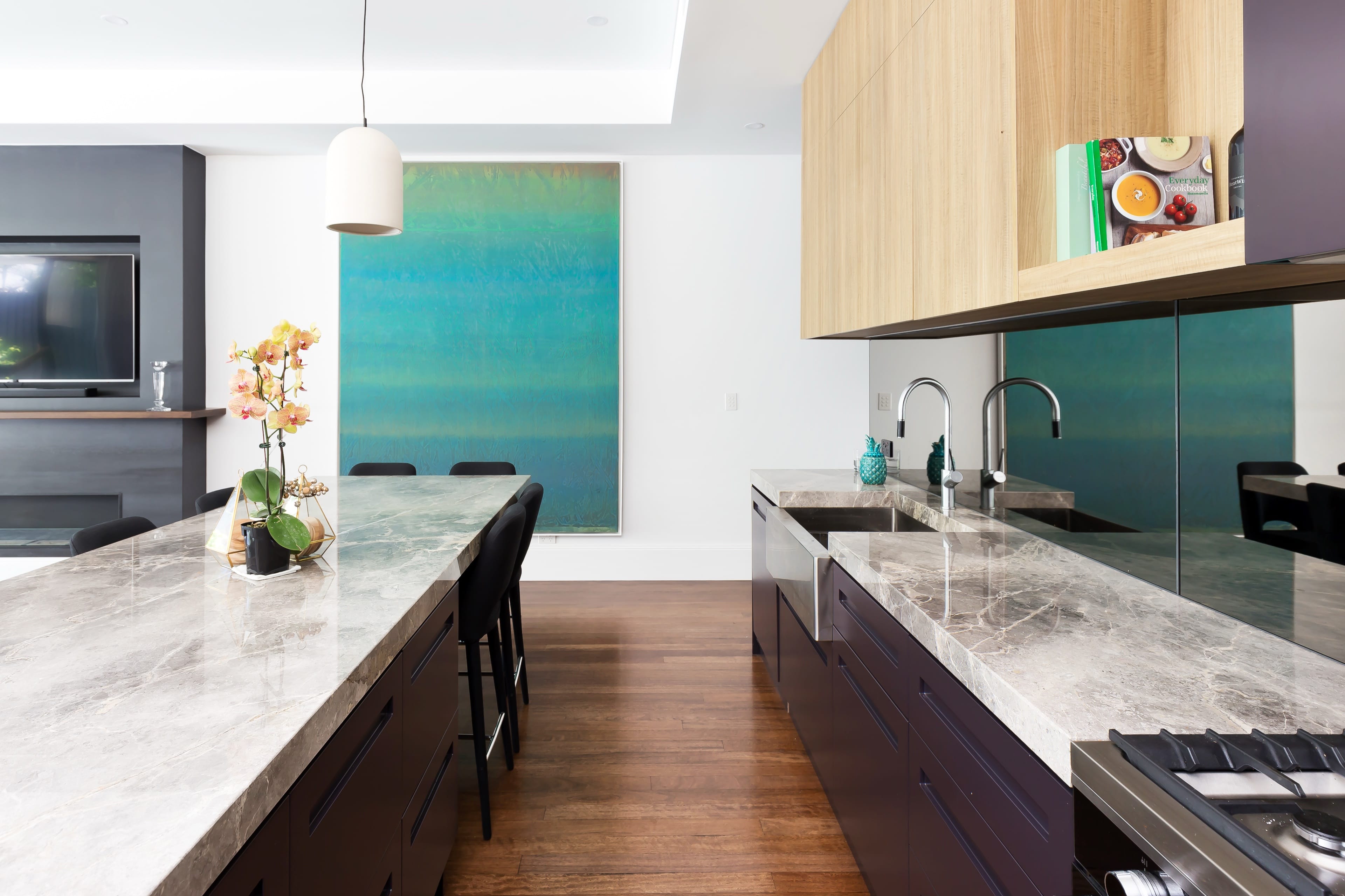 Johnston kitchen with a green splashback and stone benchtop.
