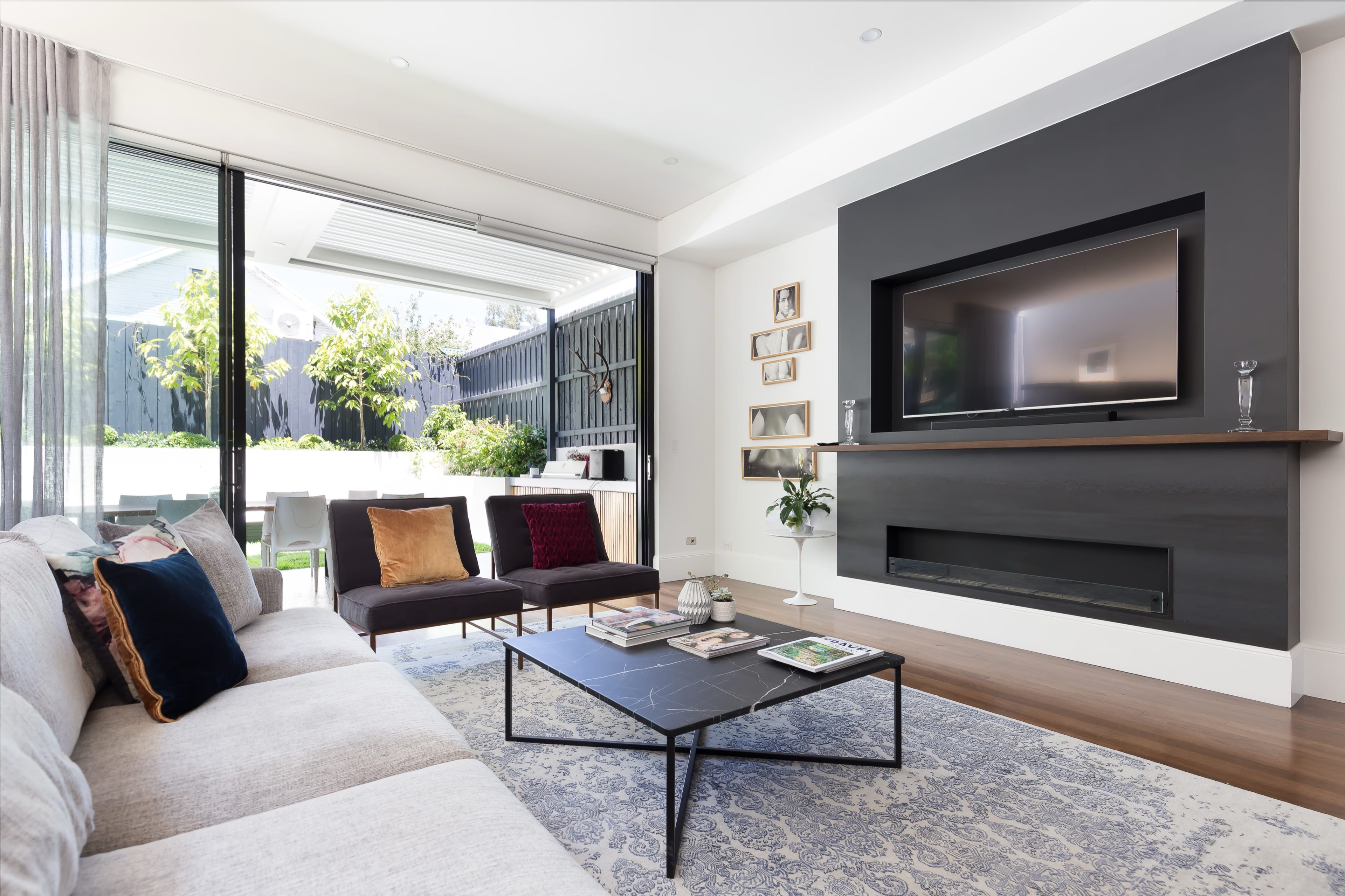 Johnston living with dark feature walls and a linear fireplace.